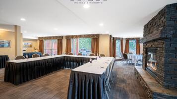 Una sala de conferencias con una larga mesa, sillas y una chimenea.