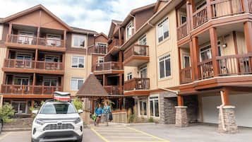 A multi-story hotel with balconies, a covered entrance, and a parking area.