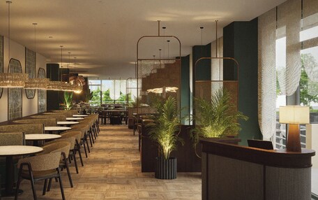 A modern restaurant with a long counter, multiple tables, and hanging light fixtures.