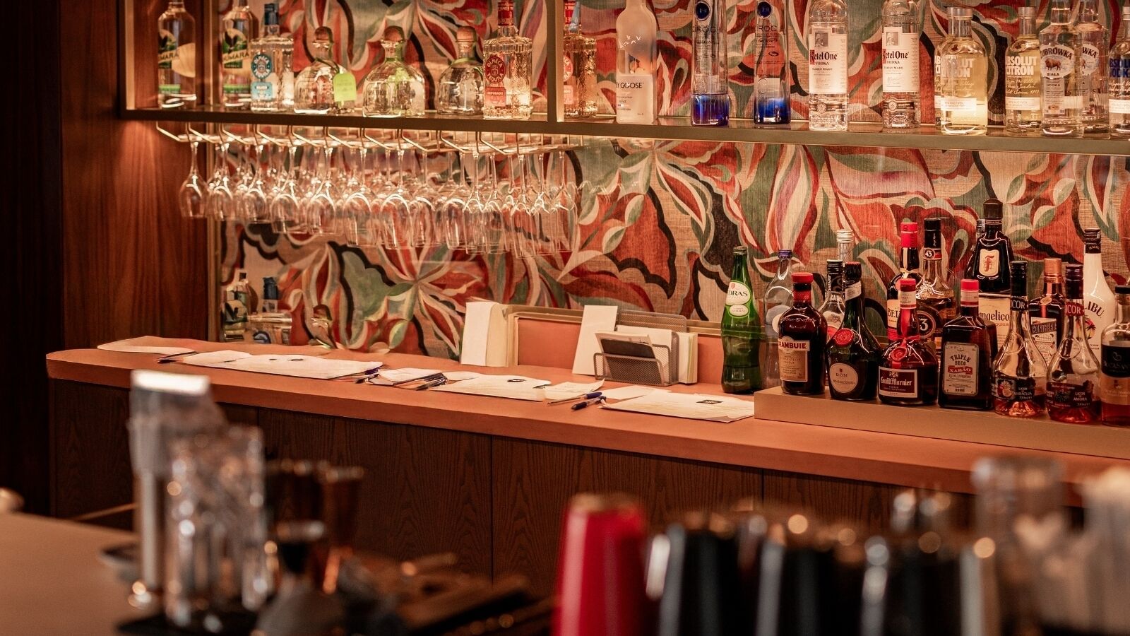 A bar area with a variety of liquor bottles and glasses.