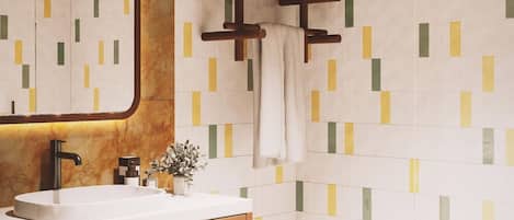 A modern bathroom with a wooden vanity, a large mirror, and a geometric-patterned wall.