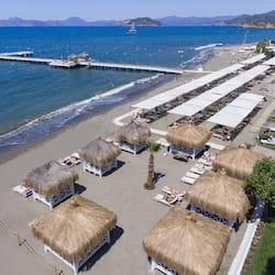 Praia particular, espreguiçadeiras, guarda-sóis, toalhas de praia