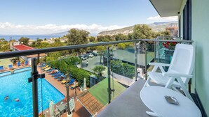 A balcony with a view of a swimming pool, lounge chairs, and a table. - Gardenia Sorrento Coast, Ascend Hotel Collection (Sorrento)
