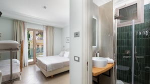 A hotel room with a bed, a desk, a bathroom with a glass shower, and a view of the outside. - Gardenia Sorrento Coast, Ascend Hotel Collection (Sorrento)