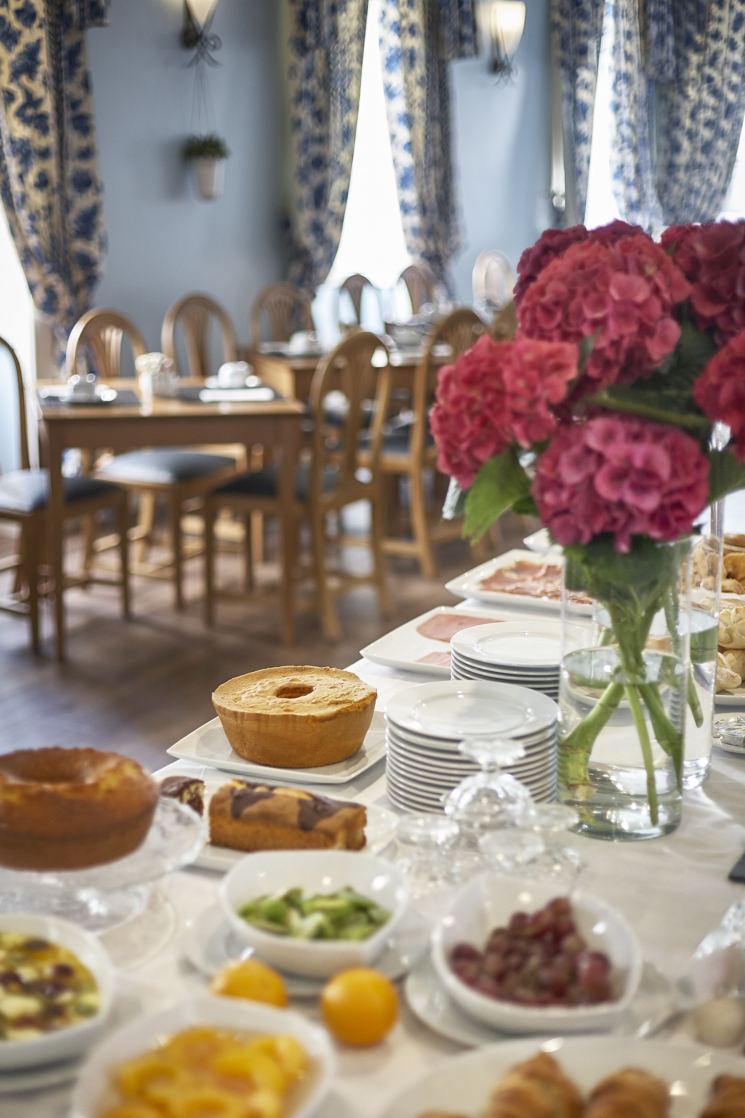 Una mesa de comedor con diversos alimentos y un jarrón de flores.