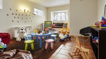 Children can play and learn in this spacious room with a large window, table, and bookshelf.
