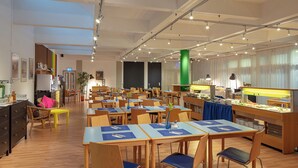 A hotel dining area with multiple tables and chairs, a buffet station, and a bright, well-lit interior. - AllYouNeed Hotel Vienna 2 (Vienna)