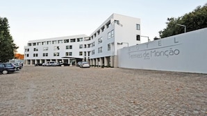 A modern hotel with a white facade, multiple floors, and a paved courtyard. - Hotel Bienestar Termas de Monção (Monção)