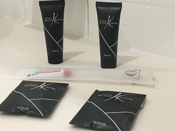 Two black tubes and two black bags with the Black Hotel logo and "ROMA" text, placed on a white surface.
