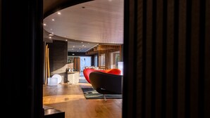 A modern interior with a curved ceiling, wooden flooring, a red sofa, and a minimalist design. - Black Hotel (Rome)
