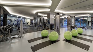 Une salle de sport moderne équipée de divers appareils d’exercice, notamment des tapis de course et des appareils de musculation.
