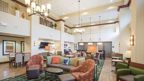 A spacious lobby with a high ceiling, multiple seating areas, and a central fireplace. - Hampton Inn & Suites Cincinnati-Union Center (West Chester)