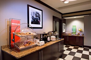 Enjoy a delicious breakfast at our buffet counter, featuring a variety of pastries, bread, and beverages.