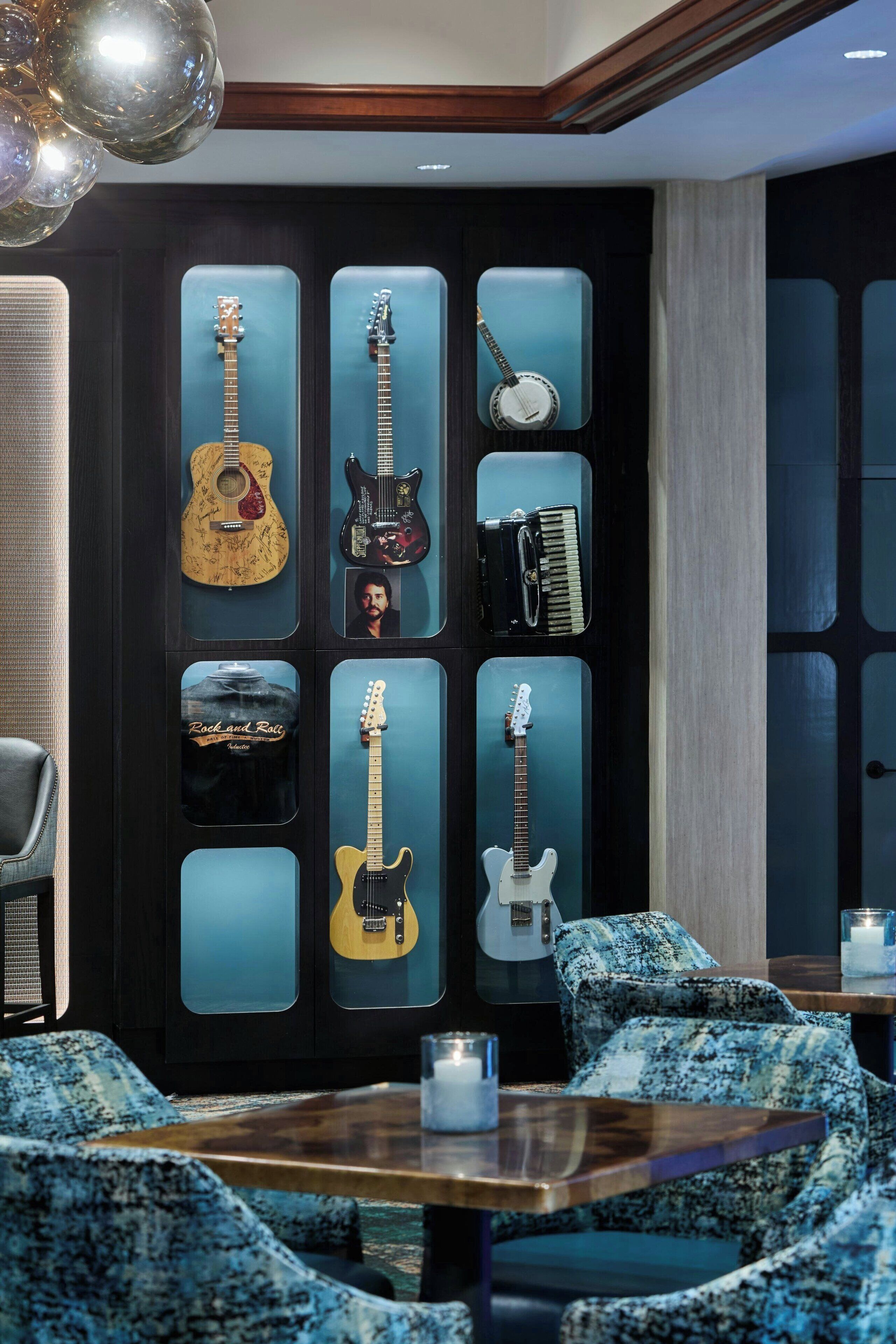 Ein Zimmer mit einer Wand, an der Gitarren hängen, und einem Tisch mit einer Kerze.