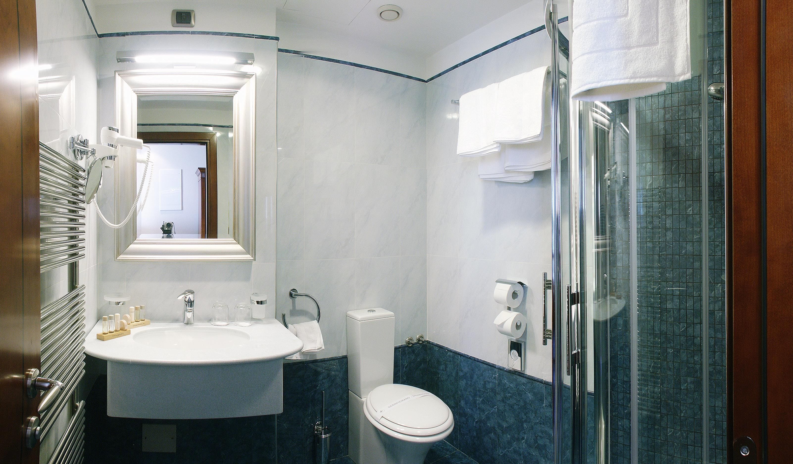 Een badkamer met een groot wastafel, toilet en een douchecabine van glas.