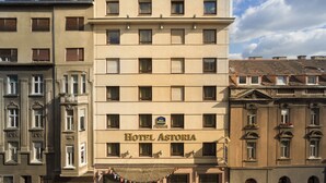 Un hôtel à la façade classique, doté de nombreuses fenêtres et d’une enseigne indiquant qu’il s’agit d’un hôtel de catégorie supérieure.