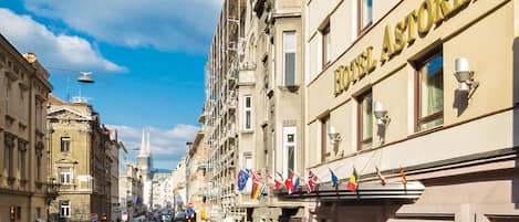 Hotelli nimeltä »HOTEL ASTORIA», josta on esteetön näkymä kadulle ja parkissa oleviin autoihin.