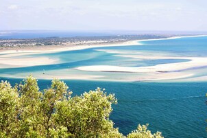 Un paisaje costero con aguas azul turquesa, playas de arena y un pueblo lejano.