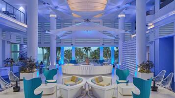 A spacious lobby with high ceilings, large columns, and a central seating area with modern chairs.