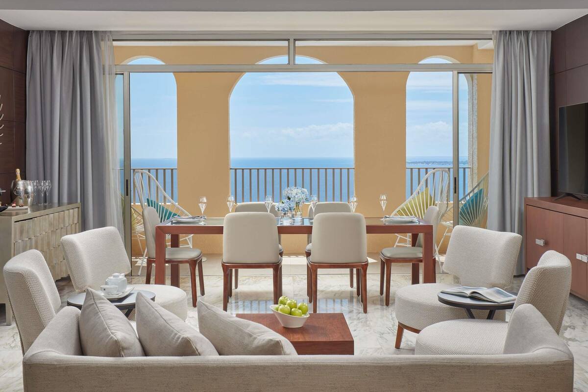 Un balcón amplio con una mesa de comedor, sillas y un sofá.
