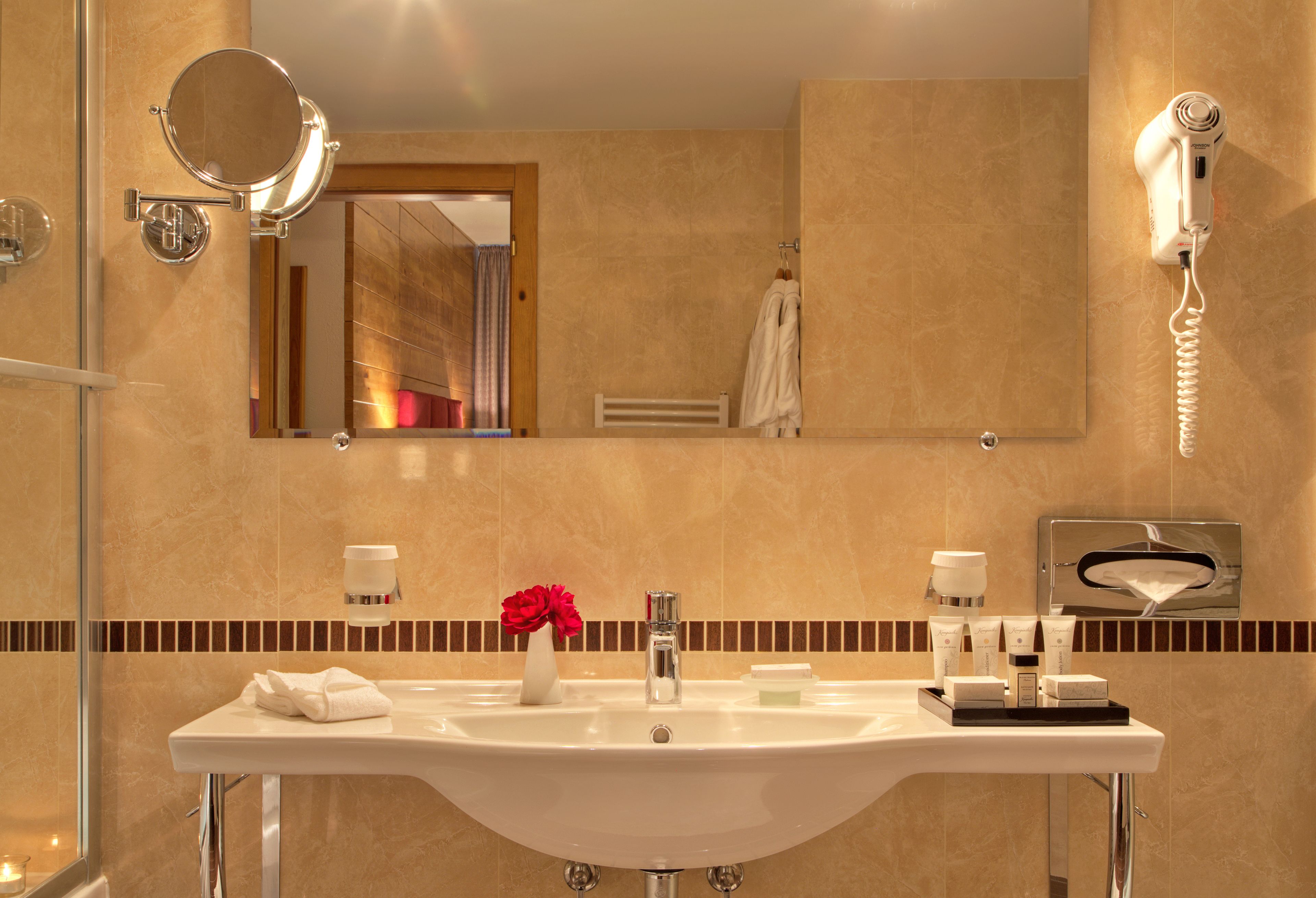 A modern bathroom with a sink, mirror, and hairdryer.
