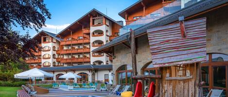 A resort with a swimming pool, a red slide, and outdoor seating areas.