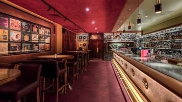Un bar con techo rojo, mostrador de bar de madera y varios carteles en la pared.
