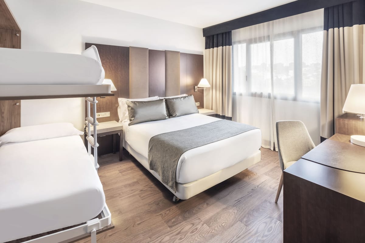 Una habitación de hotel con una cama grande, un escritorio y una silla.