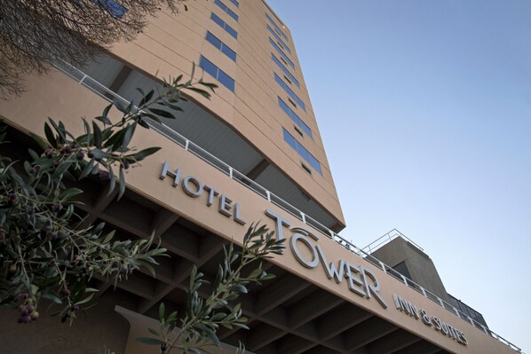 A hotel building with a sign that reads "HOTEL TOWER INN & SUITES."
