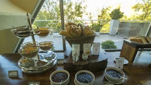 A buffet table with various food items and a bread basket.