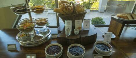 A buffet table with various food items and a bread basket.