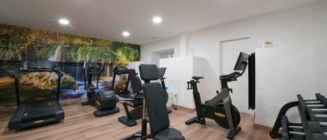 A gym with treadmills, stationary bikes, and a rowing machine.
