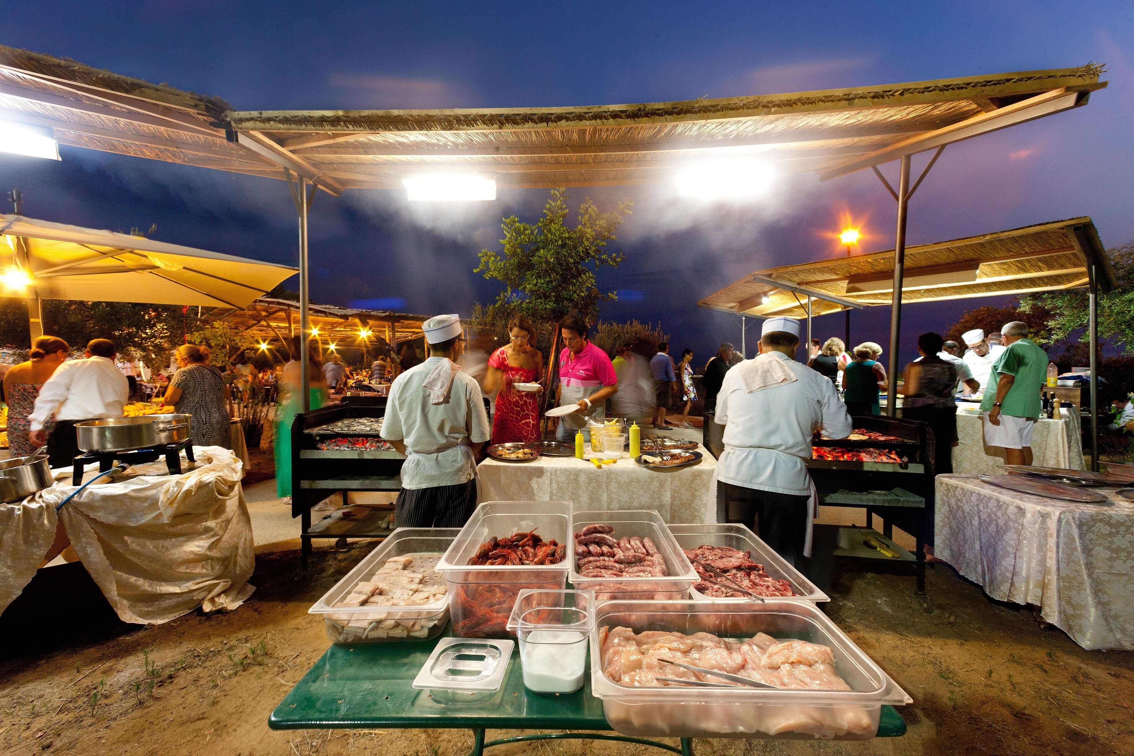 Ein Markt im Freien mit verschiedenen Essensständen unter einem Vordach.