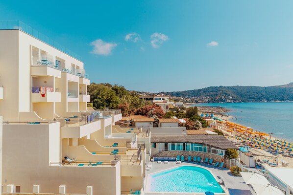 A hotel with multiple balconies, a swimming pool, and a beach view. - Hotel Saline Palinuro (Centola)
