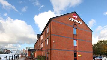 Un edificio de ladrillo rojo con un letrero que dice "dolby hotel" en la fachada.