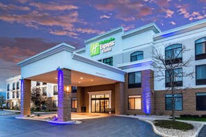 A Holiday Inn Express hotel with a covered entrance, stone pillars, and a well-lit facade.