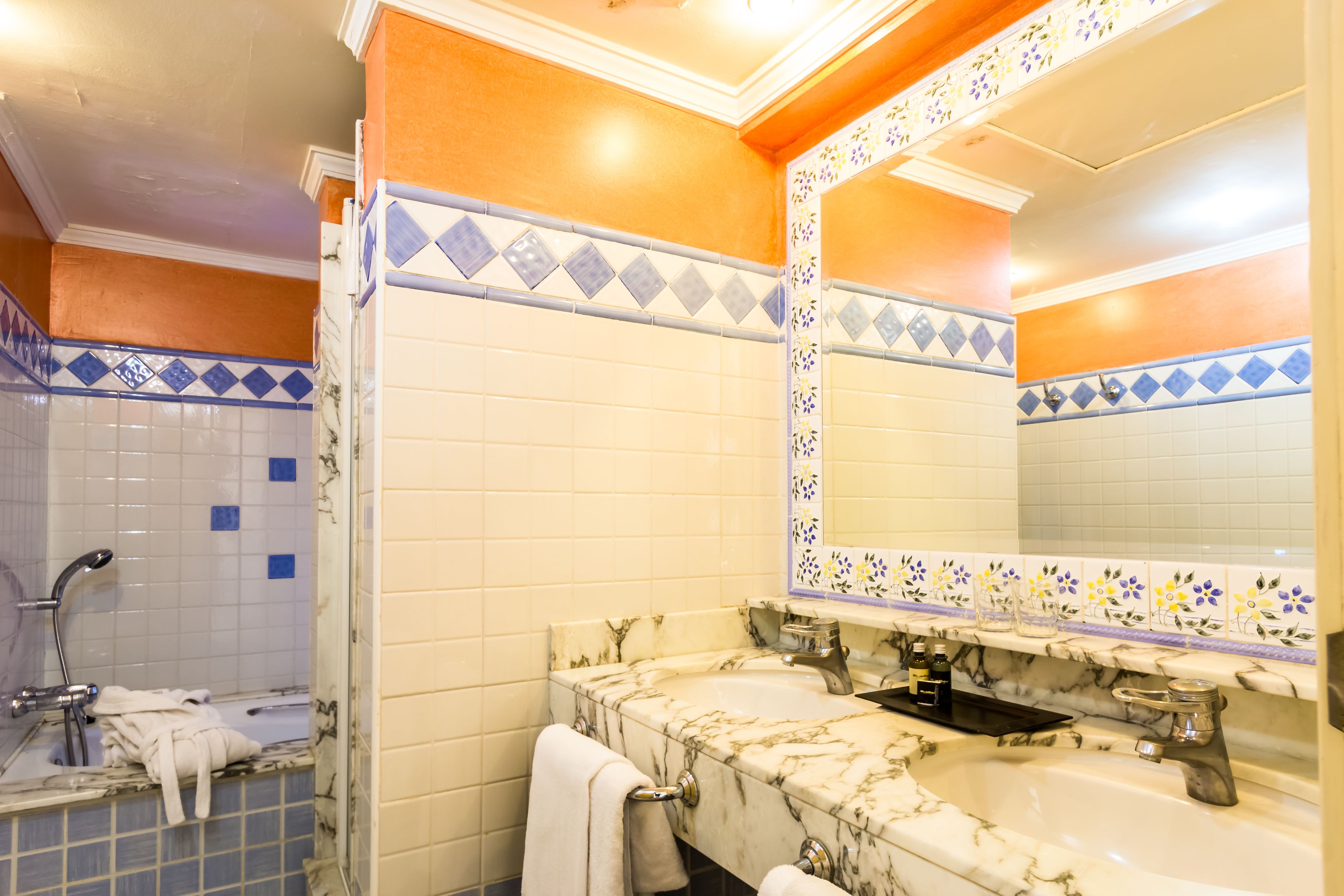 A bathroom with two sinks, a shower, and a large mirror.