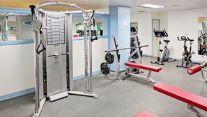 A gym with various exercise equipment, including a squat rack, bench press, and cardio machines. - BlueBay Beach Club Aparthotel (San Bartolomé de Tirajana)