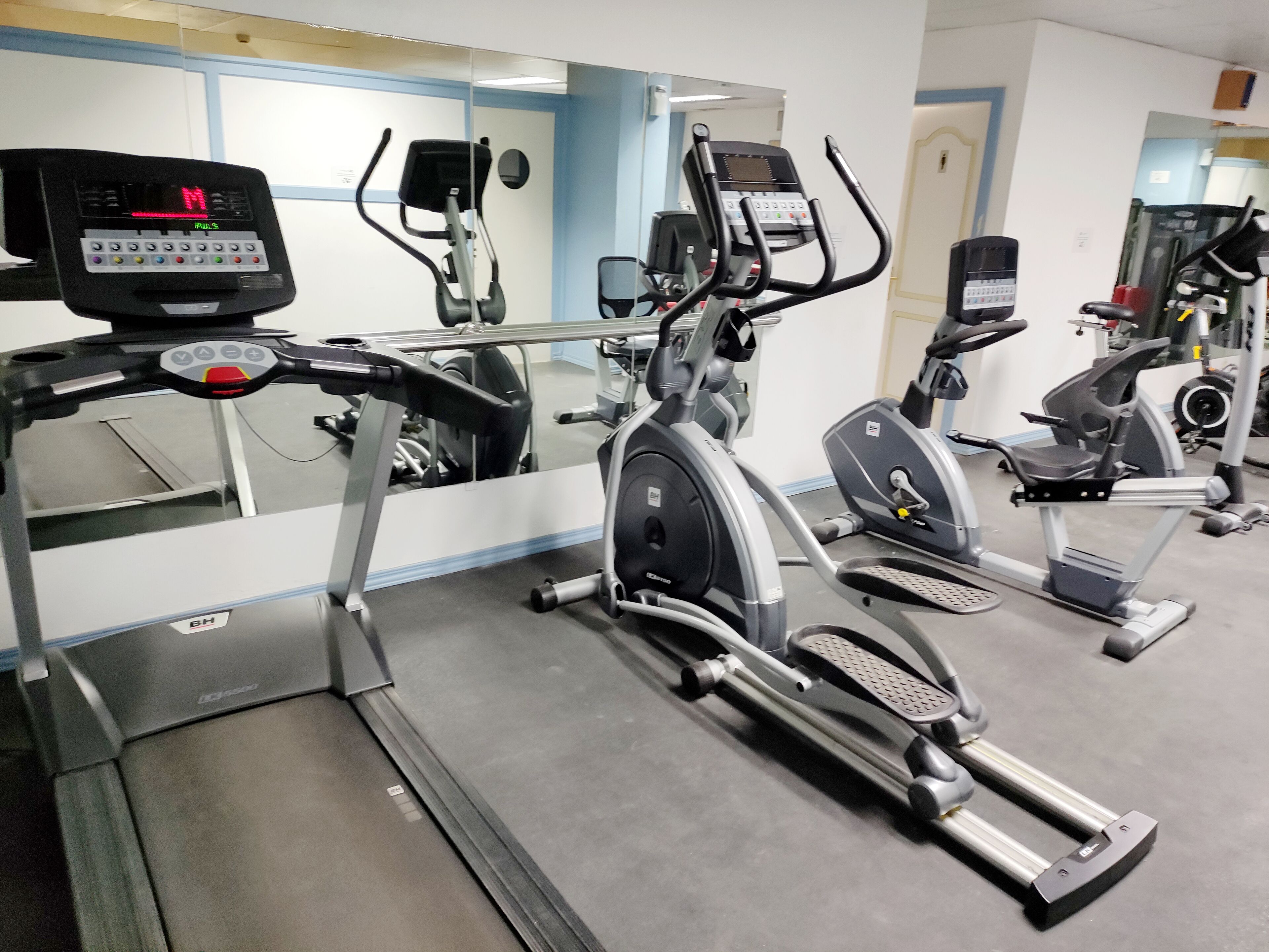 A gym with various exercise machines, including treadmills and stationary bikes.
