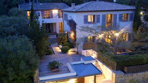 A modern house with a spacious deck, a covered patio, and a well-lit entrance. - Hotel Le Pinarello (Zonza)