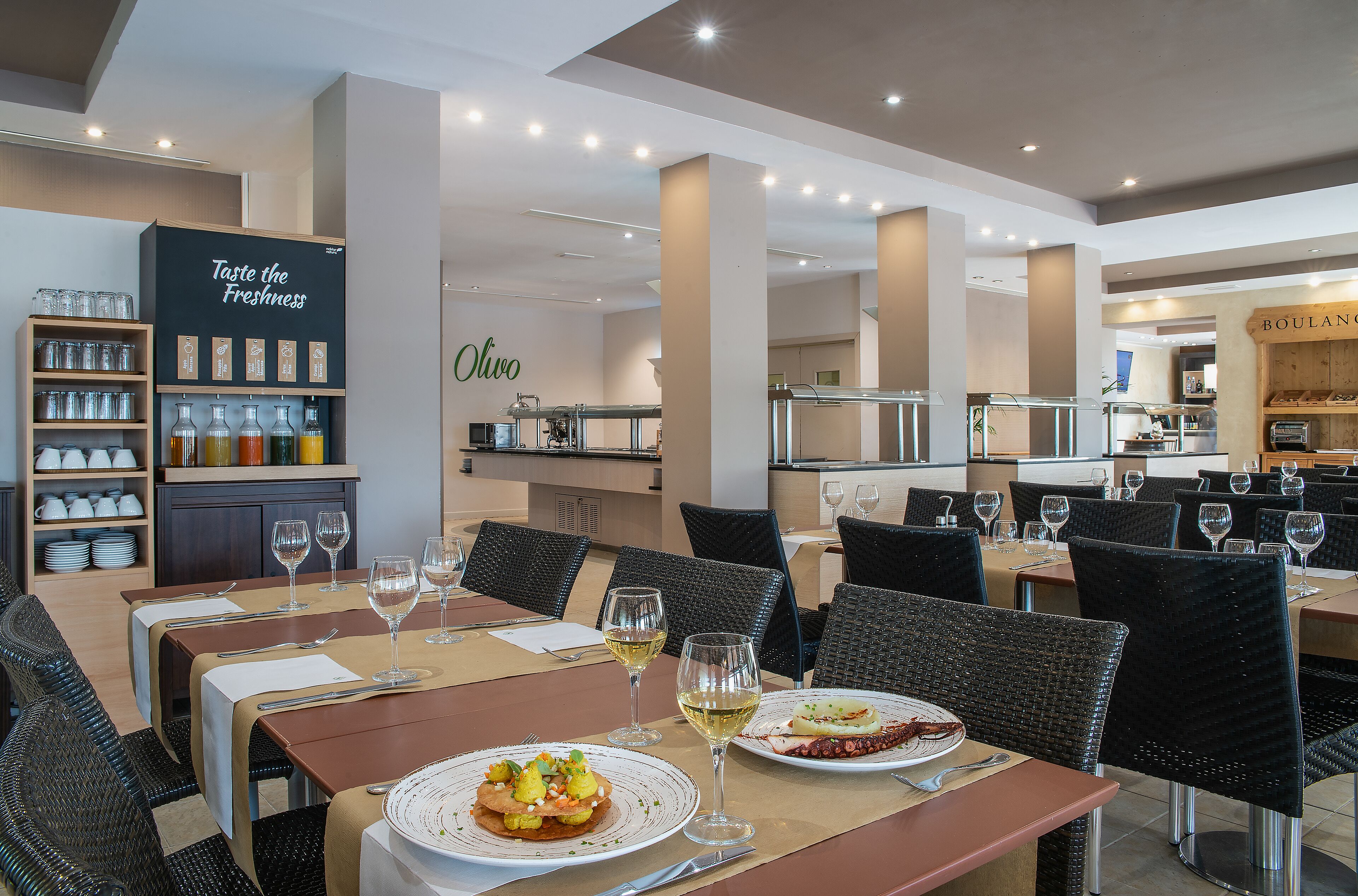 Een restaurant met gedekte tafels, wijnglazen en een menubord.