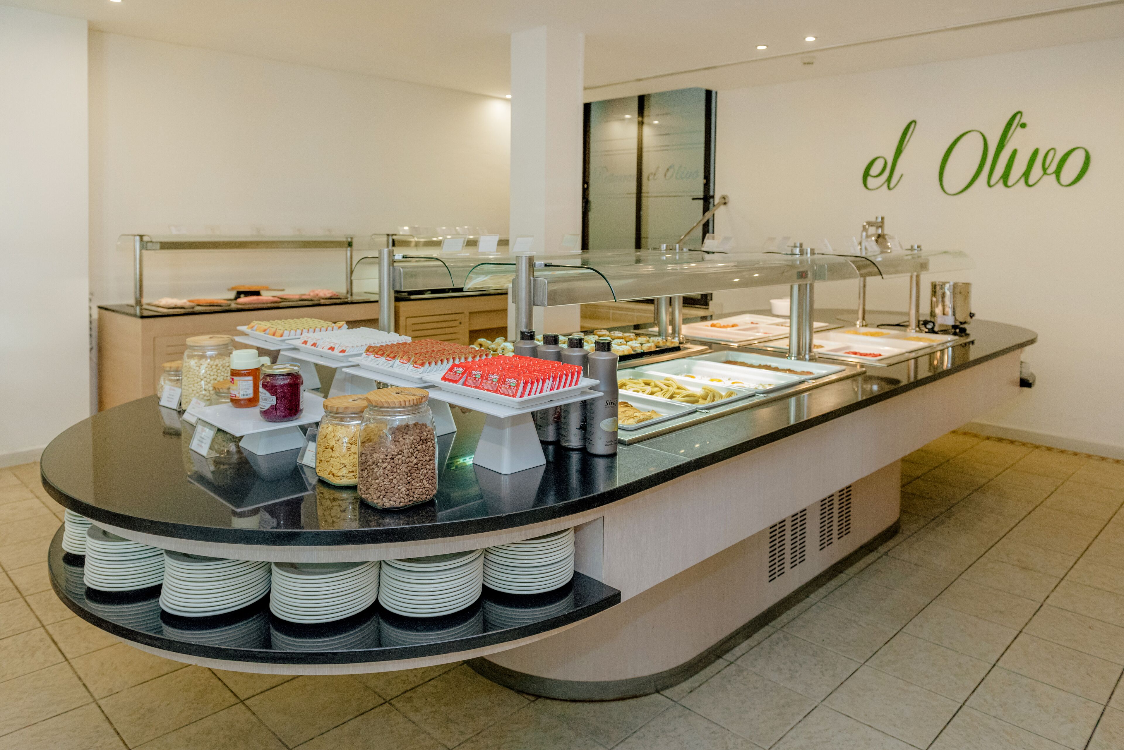 A buffet counter with various food items and condiments.