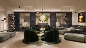 A modern living room with green upholstered sofas, a central coffee table, and a fireplace. - Falkensteiner Hotel Prague (Prague)