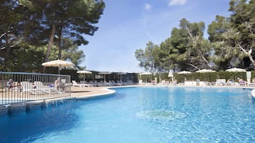 Una piscina cubierta, una piscina al aire libre, tumbonas