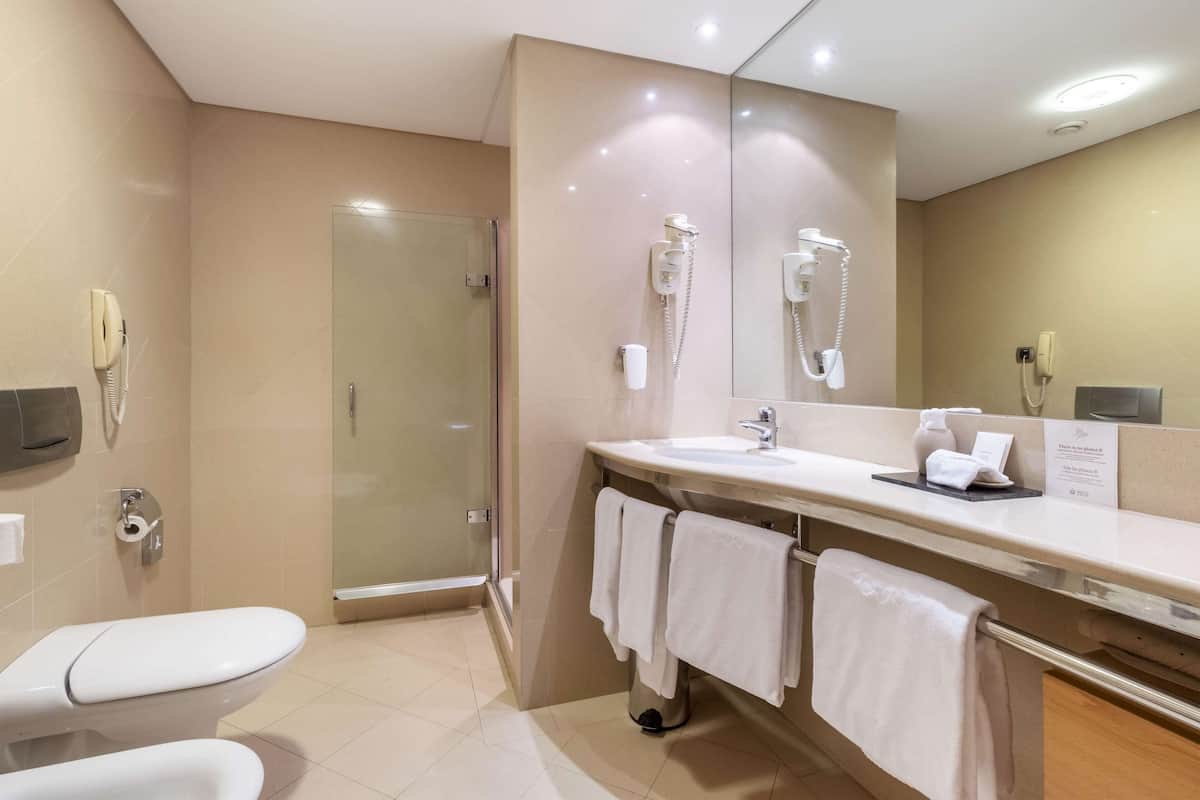 A modern bathroom with a toilet, sink, and shower.