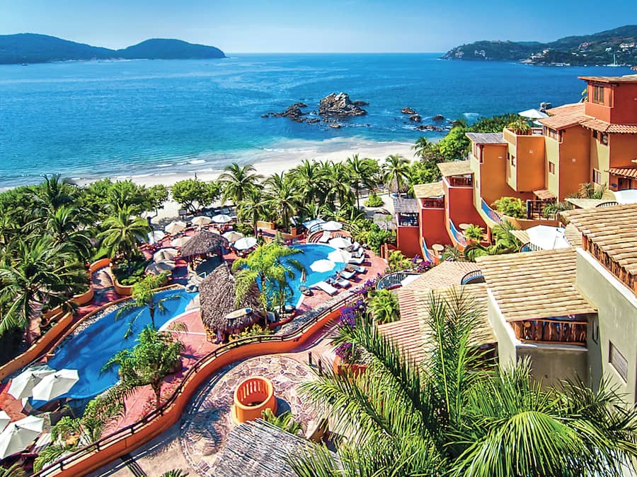 Un resort con piscina, playa y vistas al océano.