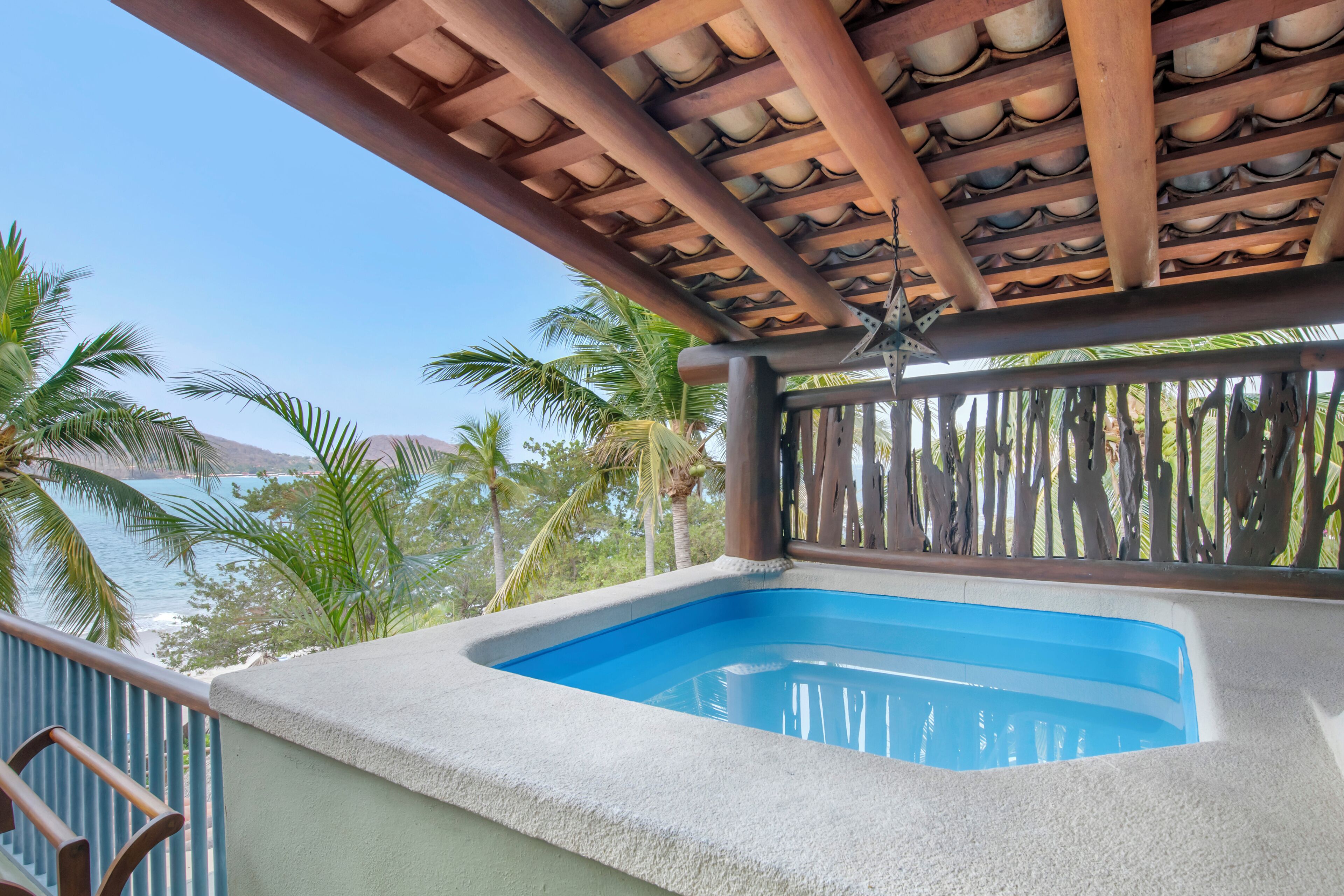 Un jacuzzi con vista despejada al océano y palmeras.