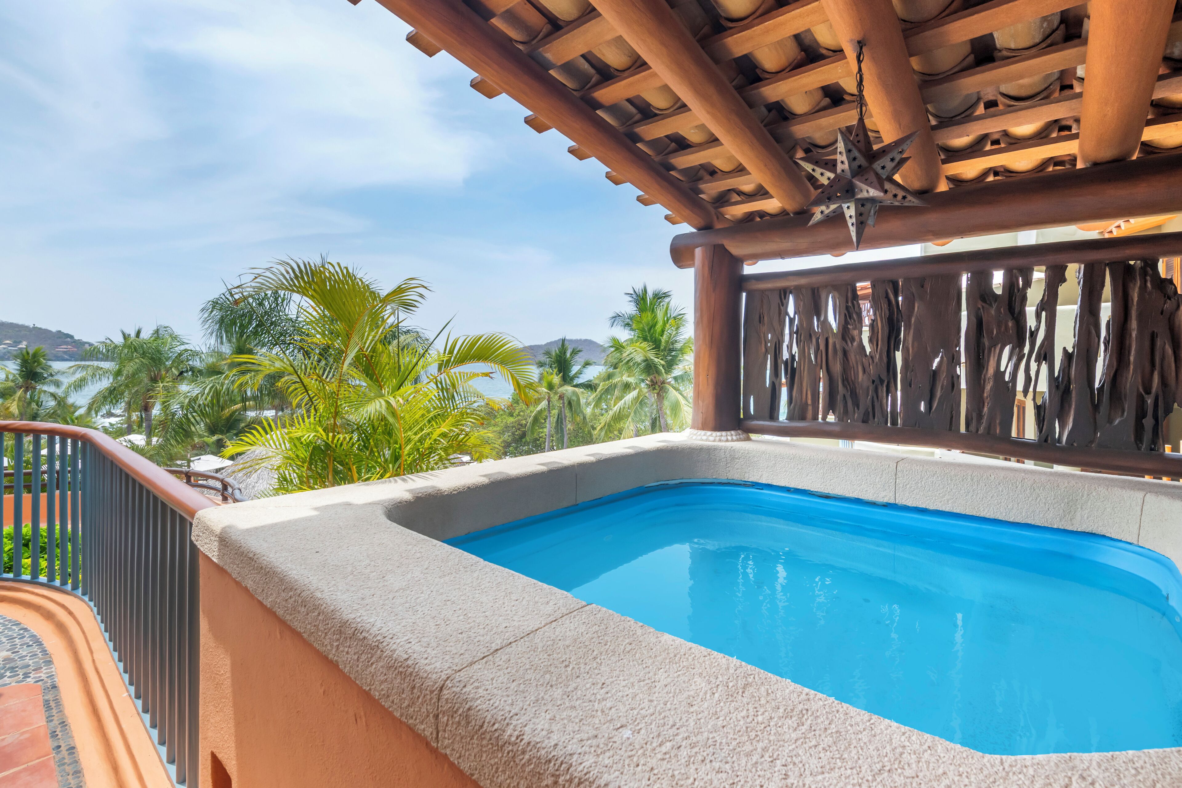 A hot tub with a clear view of palm trees and a mountainous landscape in the background.