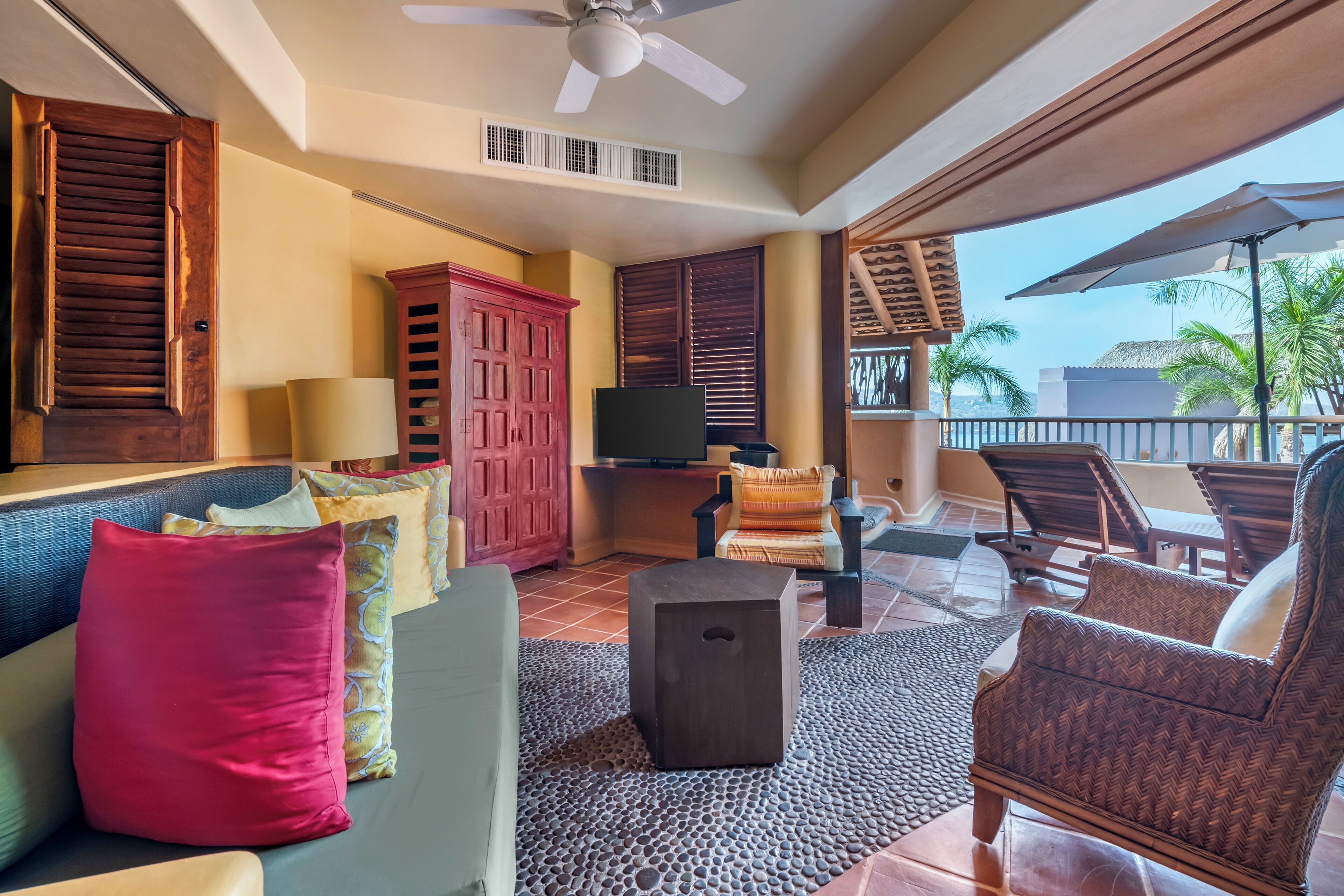 A spacious living area with a sofa, chairs, a coffee table, and a television.