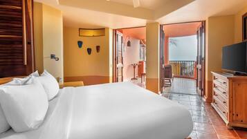 Quarto de hotel com cama, mobiliário de madeira, televisão e varanda com vista.